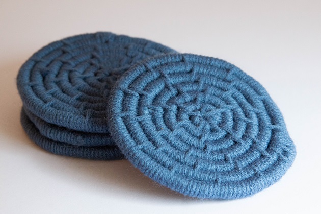 Photo of four diy coil rope coasters with blue yarn.
